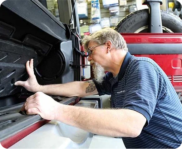 Technician installing a marine-audio speaker into a golf cart.