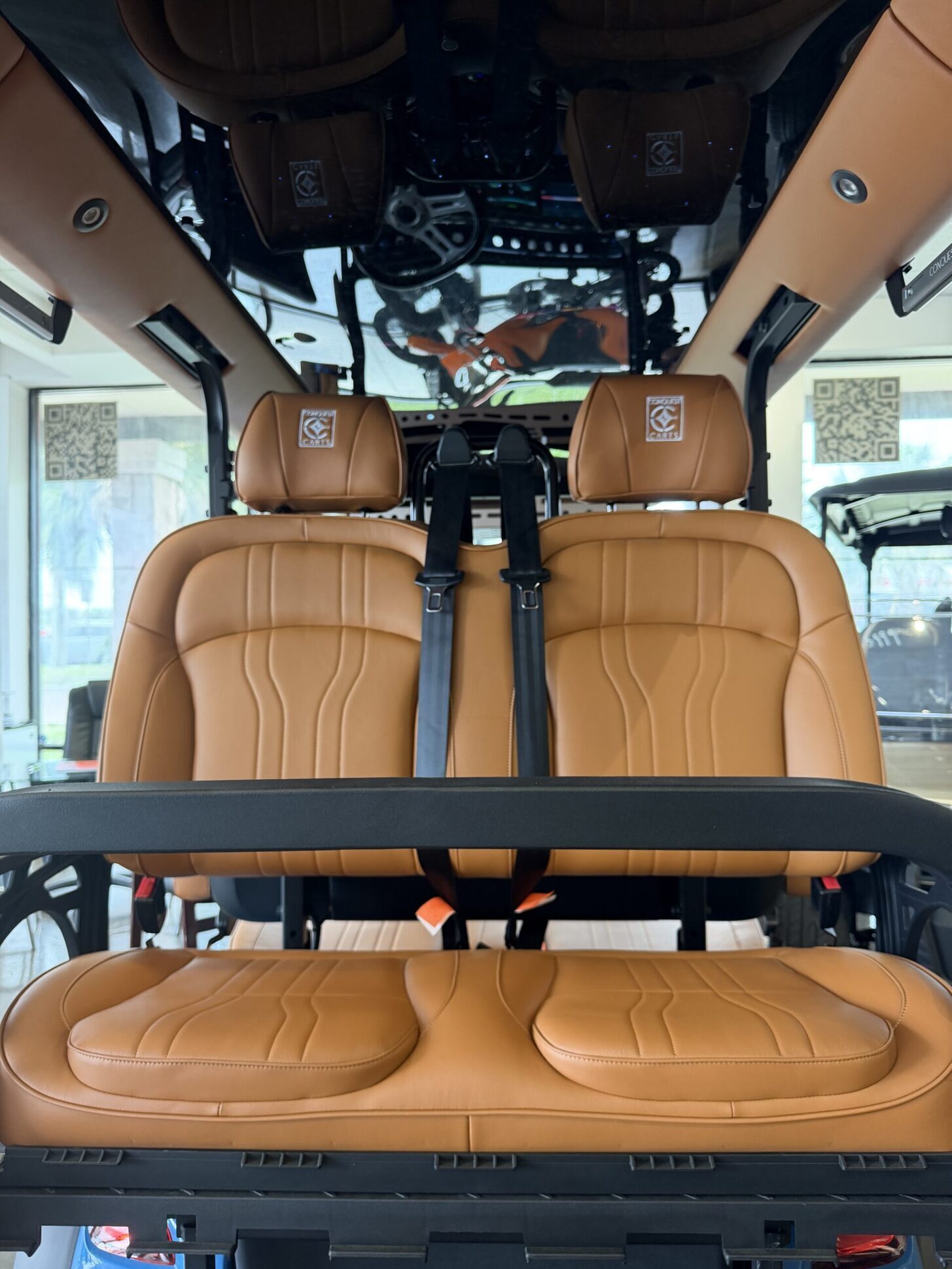 Cognac saddle-leather golf cart bucket seats with diamond stitching.