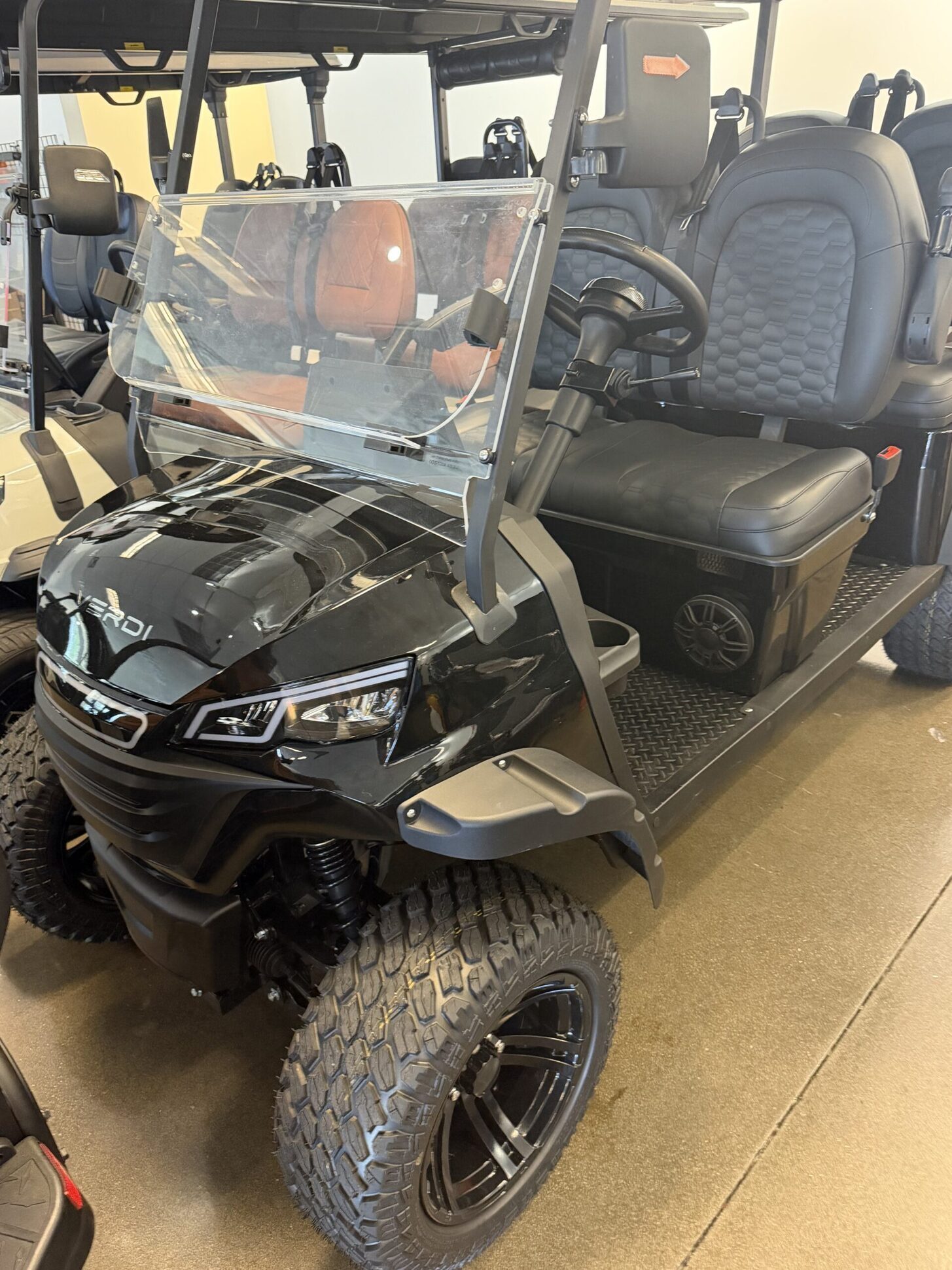 Blacked-out lifted EPIC golf cart on all-terrain wheels in the showroom.